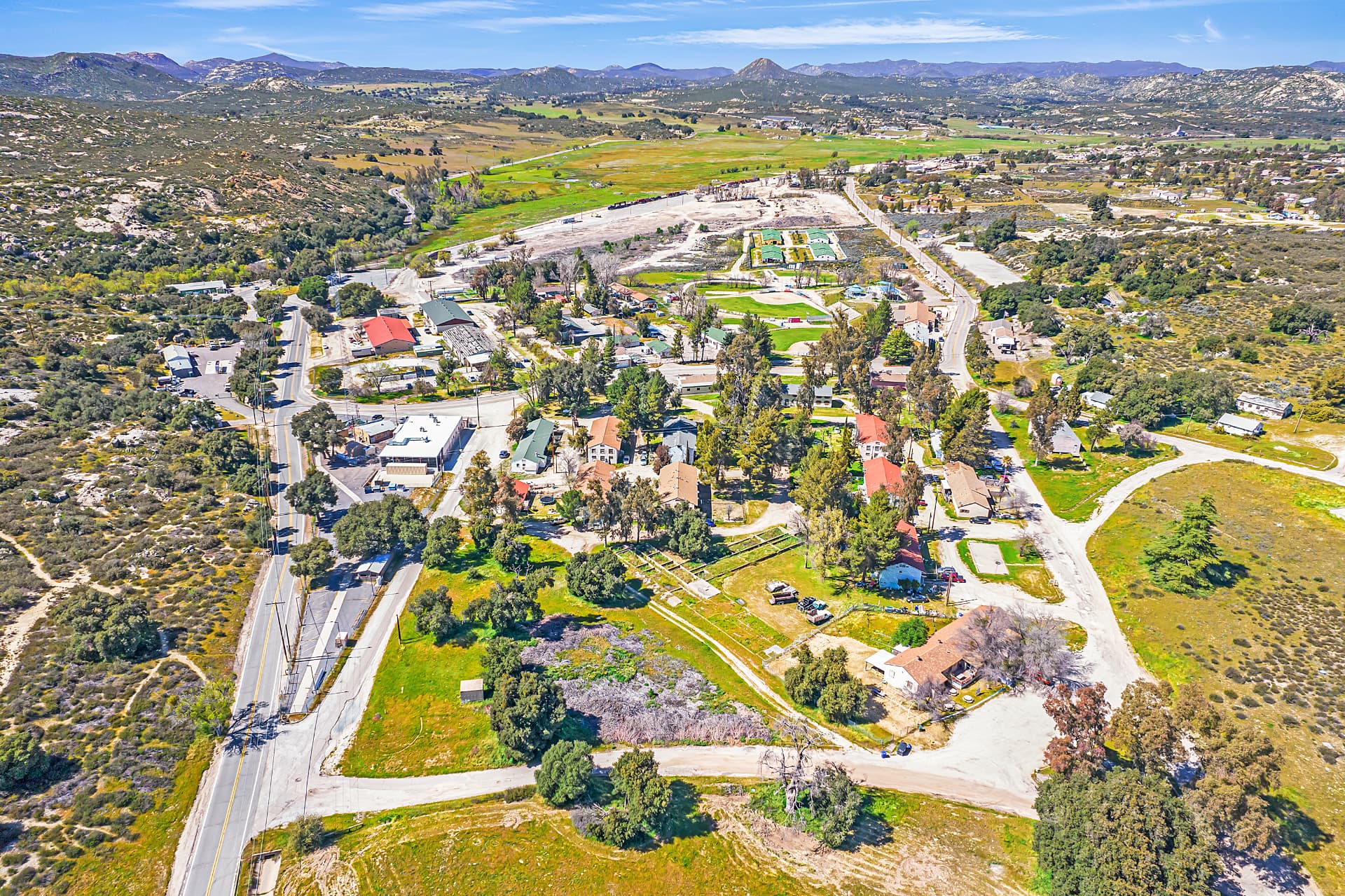 Aerial view of The Village of Campo today, with rural roads, cottages, and green desert hills surrounding the town